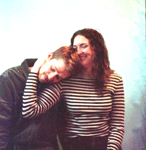 Billy and Ginny sit for a portrait, Ginny's hand around Billy's head as they laugh