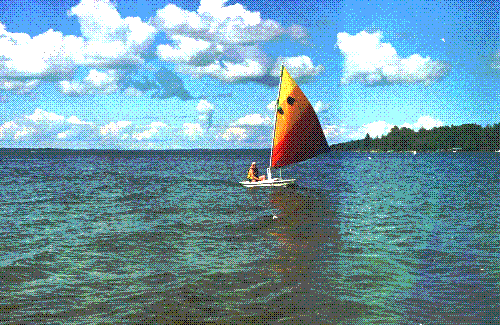 Mom sailing her sunfish on Mullett Lake on a beautiful day