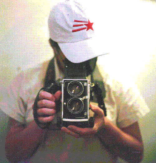 Self-portrait from the airplane bathroom wearing a white hat with a red comet