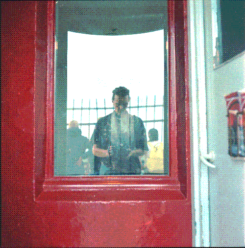 Self-portrait in a window reflection